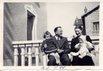 Rene and Germaine Brunschwig pose on a balcony holding their two young daughters, Arlette and Silvie, on their laps.