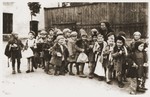 A group of pre-school children lined up with sacks in the Lodz ghetto.