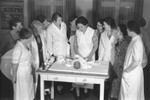 Women learn how to change an infant's diaper at a special school for teaching cooking and childcare to the wives of German political leaders in Berlin.