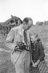 Photographer Julien Bryan comforts a ten-year-old Polish girl named Kazimiera Mika, whose older sister was killed in a field in Warsaw during a German air raid.