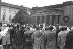 German spectators at a political rally in front of a war memorial raise their arms in the Nazi salute.
