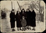 A group of Jewish women pose with a young girl at the entrance to Eisiskes.