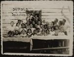 Children gather around a table in a summer camp in Dumbla.