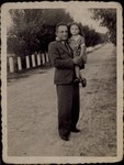 Moshe Sonenson holds his daughter Yaffa on the road leading to their summer cottage in Tetlance near Eisiskes.