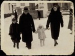 The Sonenson family walks along a snow-covered street in Eisiskes.