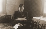 Moshe Musel reads a letter from his wife, Pola, in his room in the Kovno ghetto.