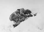 The frozen body of a Jewish prisoner who was beaten to death by the SS lies in the snow.
