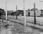 A section of the barbed wire fence and barracks in the Flossenbuerg concentration camp.