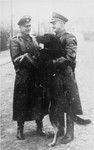Two SS officers pose with a guard dog in the Janowska concentration camp.