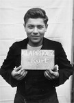 Kurt Klappholz holds a name card intended to help any of his surviving family members locate him at the Kloster Indersdorf DP camp.