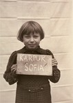 Sofia Karpuk holds a name card intended to help any of her surviving family members locate her at the Kloster Indersdorf DP camp.