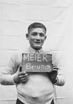 Bruno Meier holds a name card intended to help any of his surviving family members locate him at the Kloster Indersdorf DP camp.