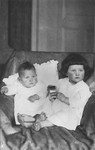 Two young Jewish sisters pose in an armchair in their living room in Bad Homburg, Germany.