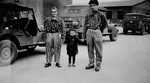 Child survivor Joseph Schleifstein (center) poses with two young men wearing concentration camp uniforms in Buchenwald.
