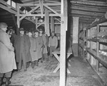 Members of a U.S. Congressional committee investigating Nazi atrocities walk through a prisoner barracks in the newly liberated Buchenwald concentration camp.