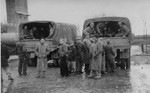 Survivors in Buchenwald gather in front of American Army trucks.