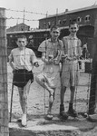 Young survivors behind a barbed wire fence in Buchenwald concentration camp.
