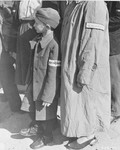 A six-year old survivor waits for his name to be called at a roll call in Buchenwald for departure to Switzerland, shortly after the liberation of the concentration camp.