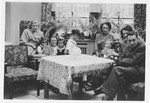 The Wollheim and Fabian families sit together in the living room of the home they shared following the imposition of the Berlin blockade.