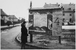 A woman reads election signs that are posted on a bulletin board in the Bergen-Belsen displaced camp.