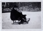 Erna Fritsche Haar and her son Roman Haar on a sled in the Rzeszow Ghetto.