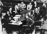 Brigadier General Telford Taylor (front right), Chief of Counsel for War Crimes, sits at the prosecution table with his staff during the reading of the charges against the defendants in the RuSHA Trial.