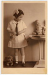 Studio portrait of a young Jewish girl with a doll and stuffed animal.