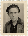 Studio portrait of a Buchenwald Boy [probably in Ambloy] wearing a beret.