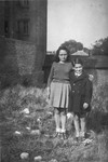 Denise and Jean-Claude Bystryn stand in a field next to their apartment house in Colombes after the war.