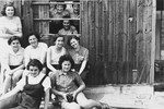 Group portrait of German-Jewish teenage girls in front of a rustic wooden building while on a Sunday outing to the country.