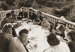 A group of Jewish DPs living in Sweden have dinner on a balcony.