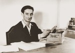 Portrait of Moses Kornberg, the head of the Stuttgart DP camp commissary, checking records in his office.
