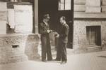 Police officer M. Ritter checks the papers of a camp resident at the entrance to a building in the Stuttgart DP camp.