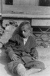 A destitute child sleeps on the pavement in the Warsaw ghetto.