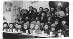 Group portrait of young Jewish children having a snack at the Yavneh Hebrew school in Grabowiec.
