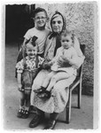Portrait of Sheindl Rajs in the Ulm displaced persons camp surrounded by her grandchildren Srulek, Rivka and Gitele.