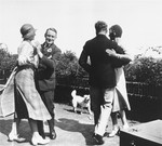 Willem Arondeus (left) and writer A. Roland Holst (right) dancing at a garden party.