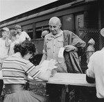 Newly arriving refugees are checked in at the Fort Ontario shelter by representatives of the War Relocation Authority and the U.S.