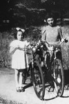 Anita poses with her bicycle after the war with a cousin of her rescuer, Father Kujata.