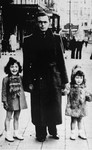 Annette and Margo Lederman, two Jewish children in hiding, pose with one of the sons of their rescuers on a street in Rumst, Belgium.