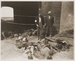 German civilians from Gardelegen stand beside the bodies of concentration camp victims killed by the SS in a barn outside of the town.