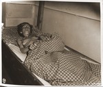 An emaciated female Jewish survivor of a death march from the Gruenberg labor camp to Volary, lies in an American military field hospital in Volary, Czechoslovakia.