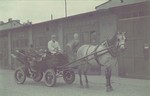 Mordechai Chaim Rumkowski, chairman of the Lodz ghetto Jewish Council, is driven in a horse drawn carriage through a street of the ghetto.