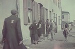 Hans Biebow, German administrator of the Lodz ghetto, talks to a goup of Jewish women on the doorstep of a building in the Lodz ghetto.