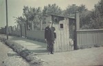 A Jewish border policeman stands by a guardhouse on a street corner in the Lodz ghetto.