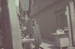 A bearded, religious, Jewish vendor stands by his stall in the Lodz ghetto.