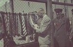 Ghetto administrator, Hans Biebow examines some ties for sale in the outdoor market of the Lodz ghetto.