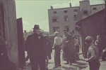 A group of ghetto residents congregate on a street of the Lodz ghetto.