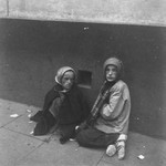 Two children beg for food on the streets of the Warsaw ghetto.