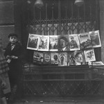 A young boy sells German Nazi periodicals on a street in the Warsaw ghetto.